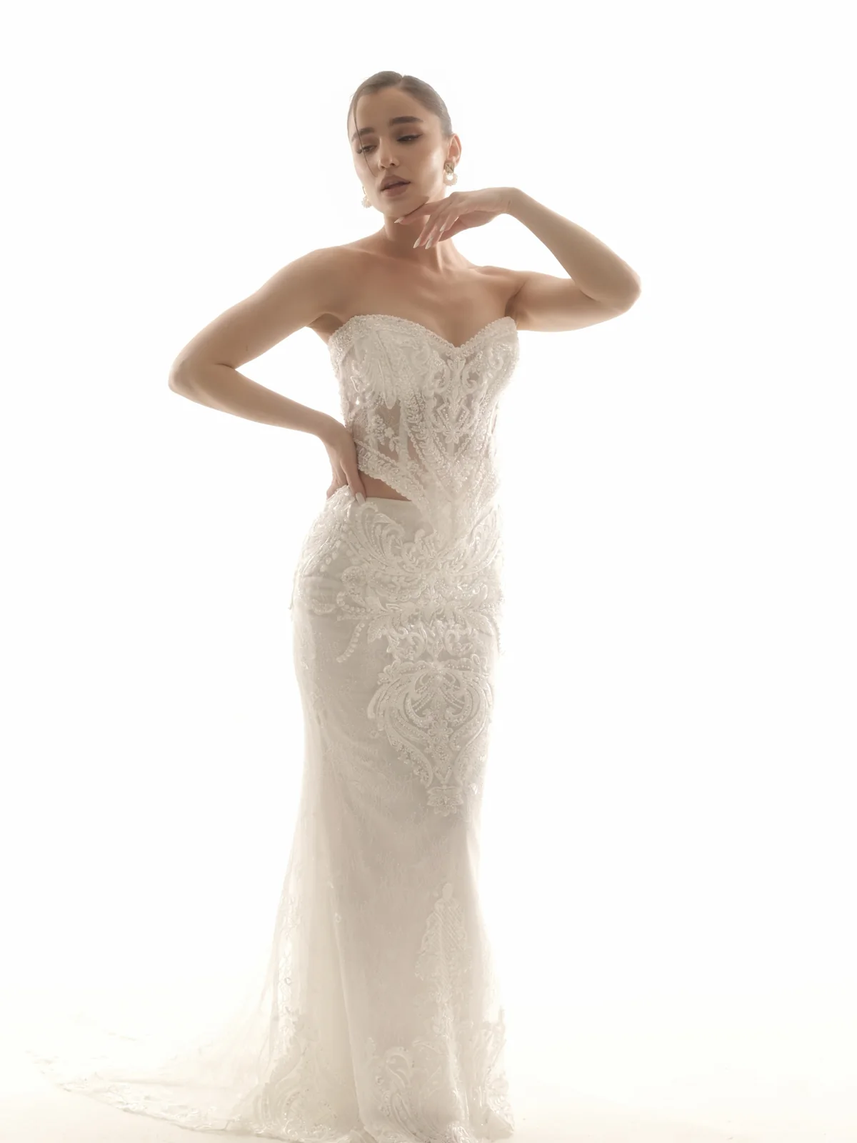 Full-length bridal portrait of Ninia in an embellished white wedding dress in a Tbilisi studio
