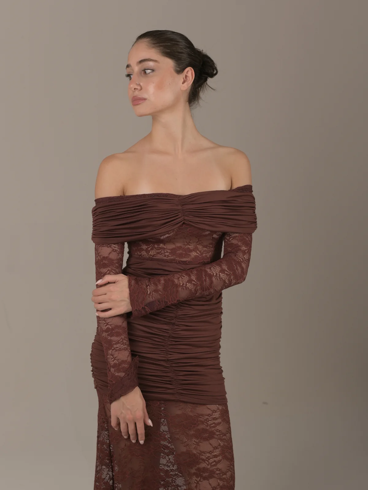Elegant portrait of Mari in an off-shoulder brown lace dress against a neutral studio background