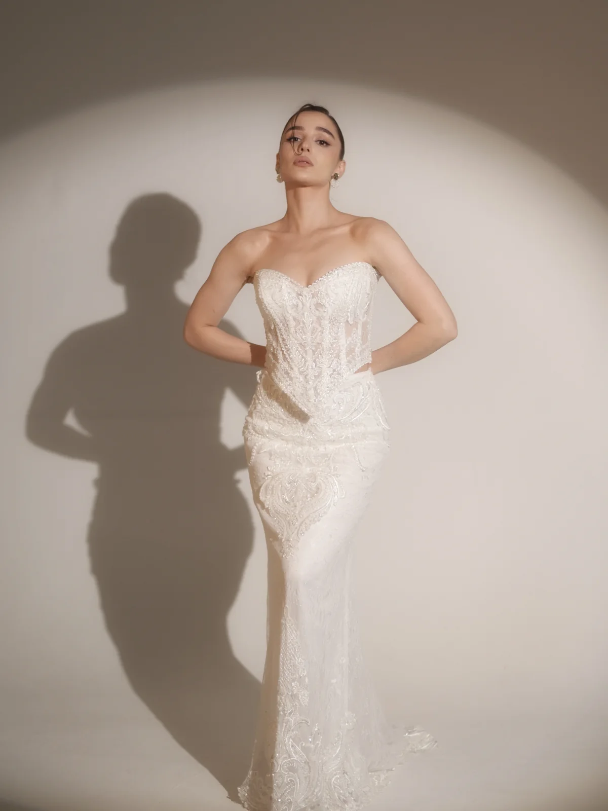 Full-body fashion photograph of Ninia in a white bridal gown with a sculpted shadow