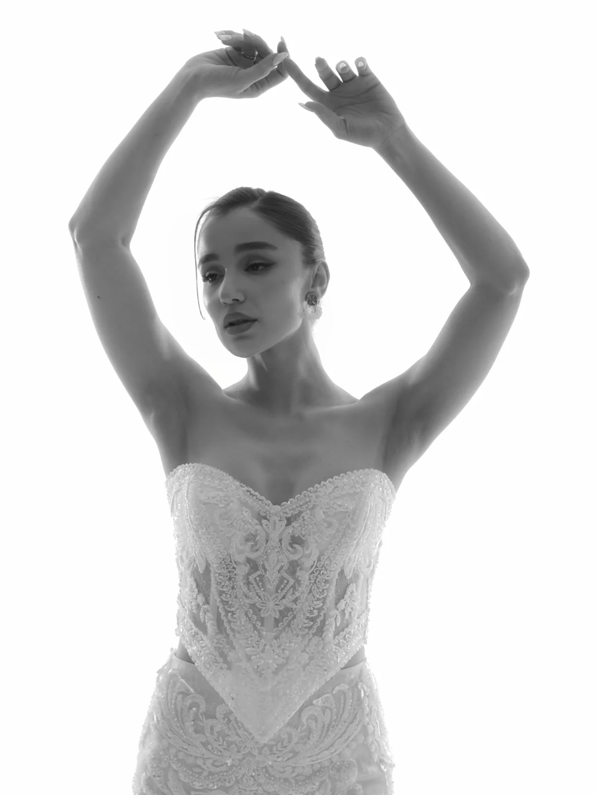 Black-and-white beauty portrait of Ninia in a white bridal dress under backlight