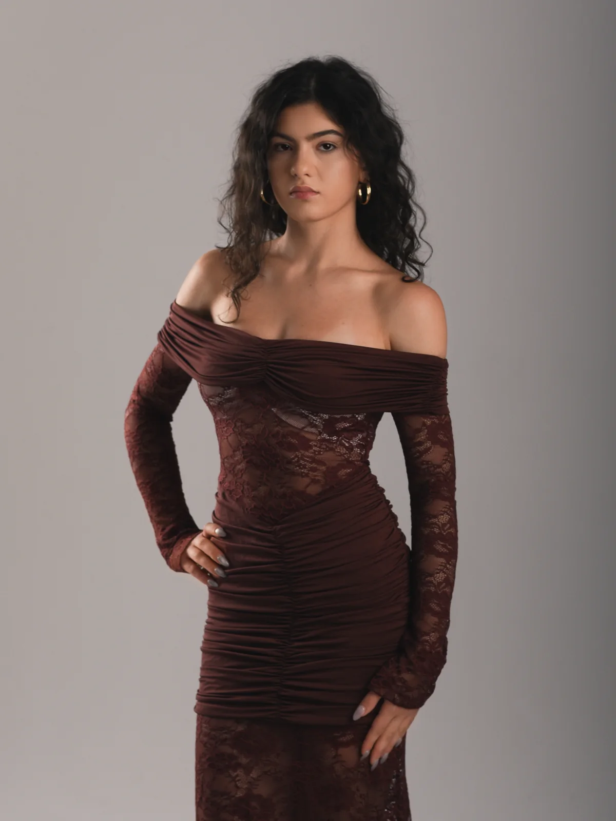 Close fashion portrait of Mariami in a burgundy dress against a neutral studio background