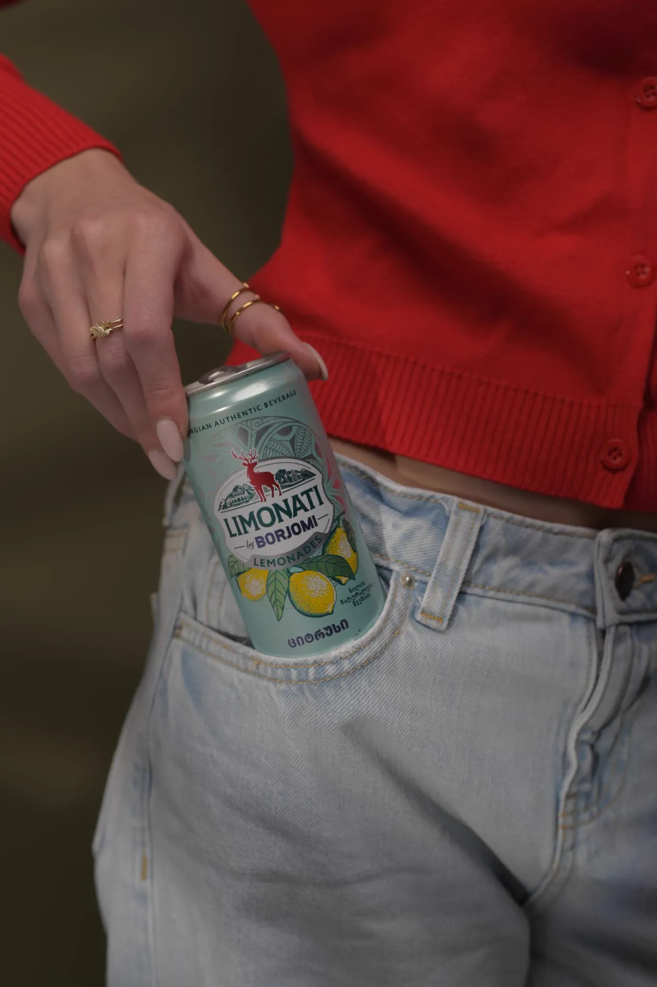 Limonati by Borjomi lemonade can tucked into a jeans pocket — lifestyle commercial product photography for a beverage brand