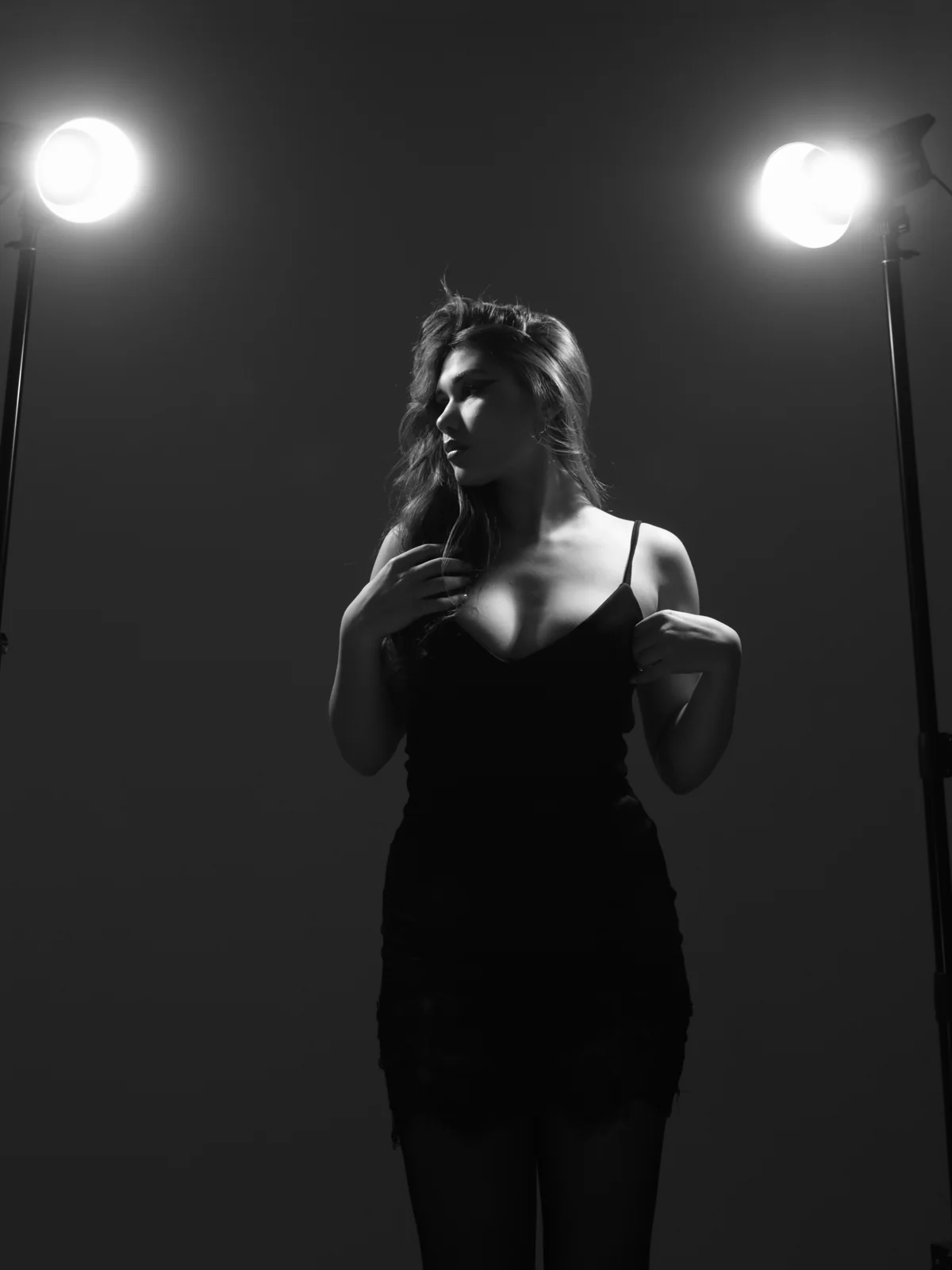 Black-and-white fashion portrait of Mariam in a black dress between two studio lights