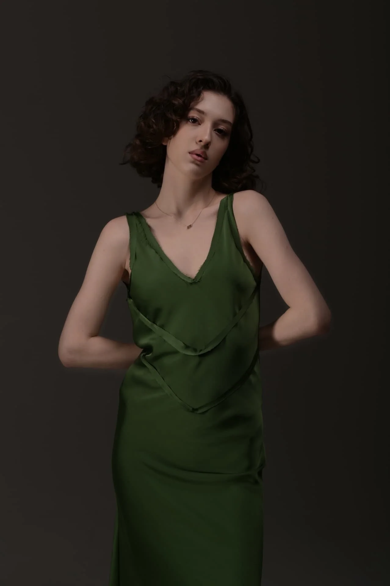 Close fashion portrait of Lizi in a green dress under soft studio light