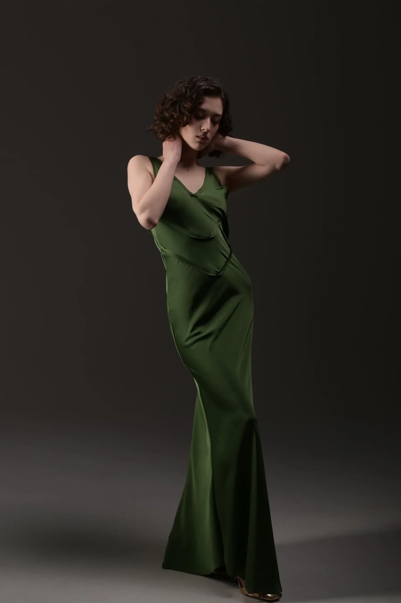 Lizi posing in a green satin dress for an editorial studio photoshoot