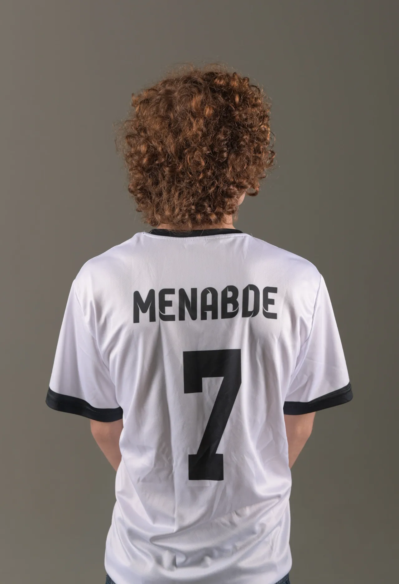 Back view of a white custom football jersey with Menabde 7 printing — sportswear product photography in a Tbilisi studio